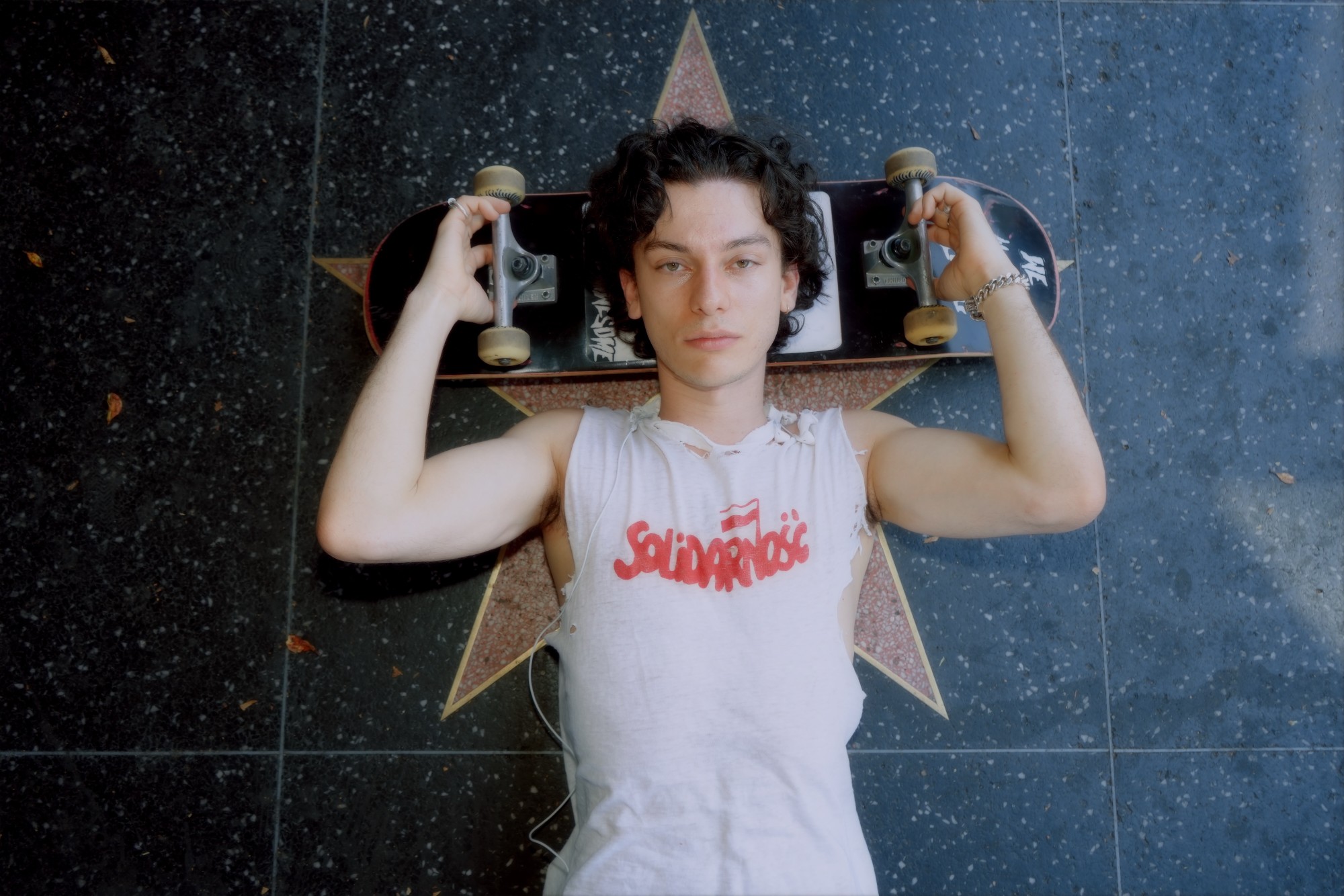 Henry Morris lying on a Hollywood Walk of Fame star with a skateboard