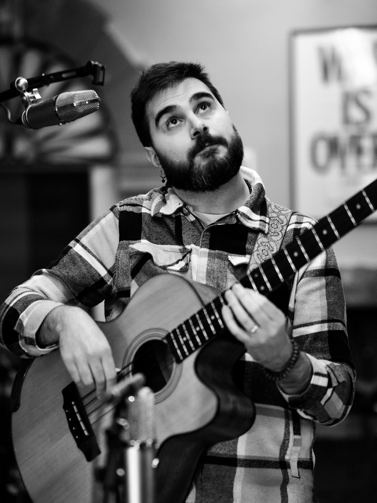 Pier Piras playing the acoustic bass guitar, in black and white