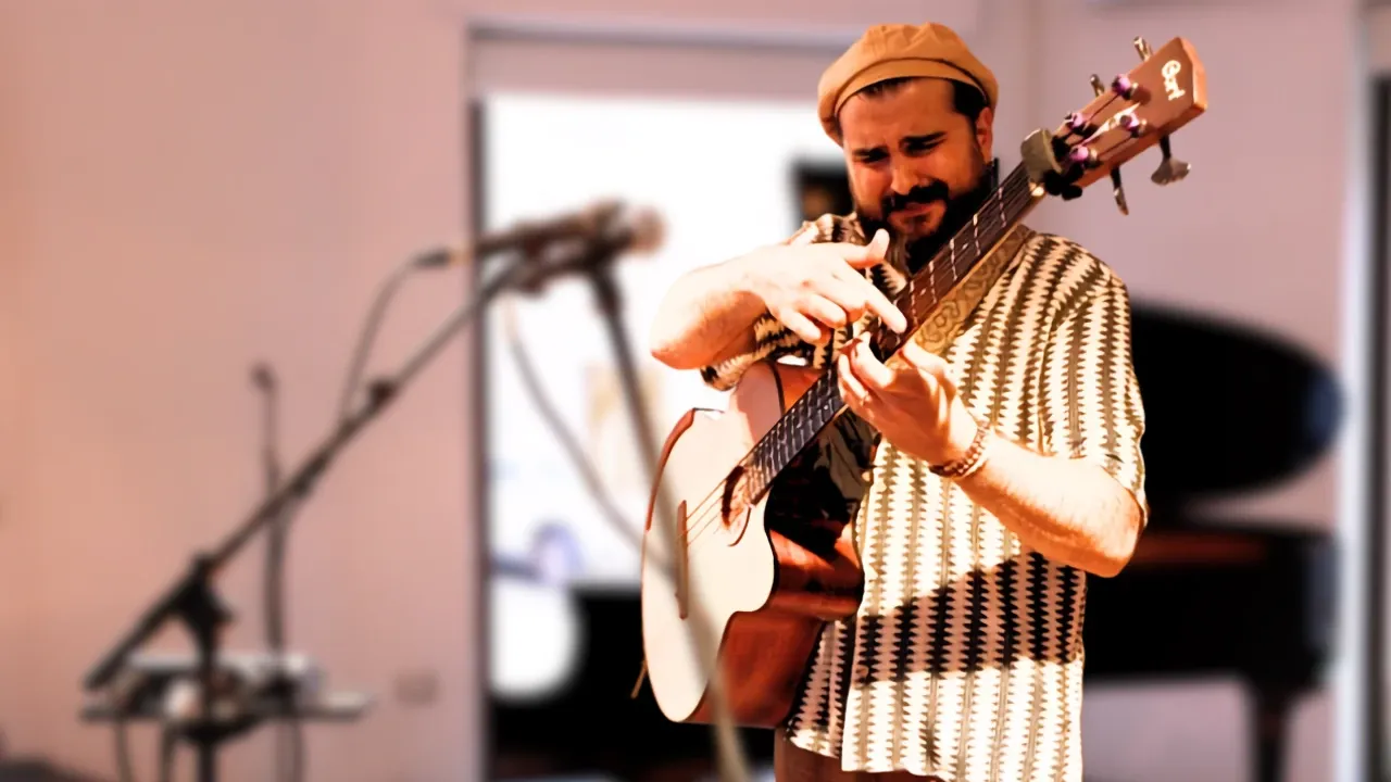 Pier Piras playing the acoustic bass guitar on stage
